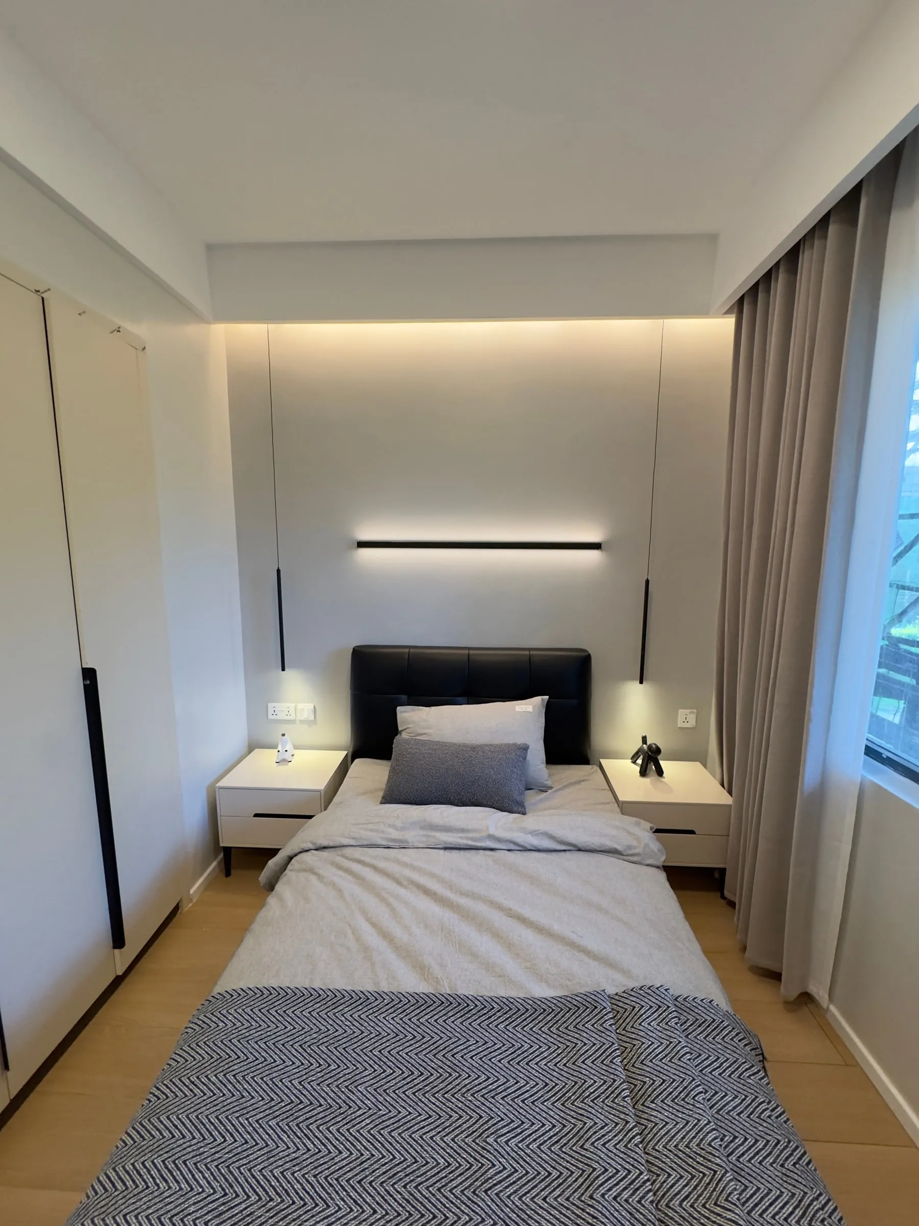 Bedroom with oak-effect flooring, bedside tables and curtains